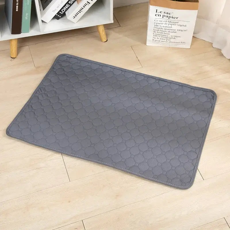 Grey quilted dog cooling mat on wooden floor, ideal for pet comfort on hot days, featuring washable, waterproof polyester design.