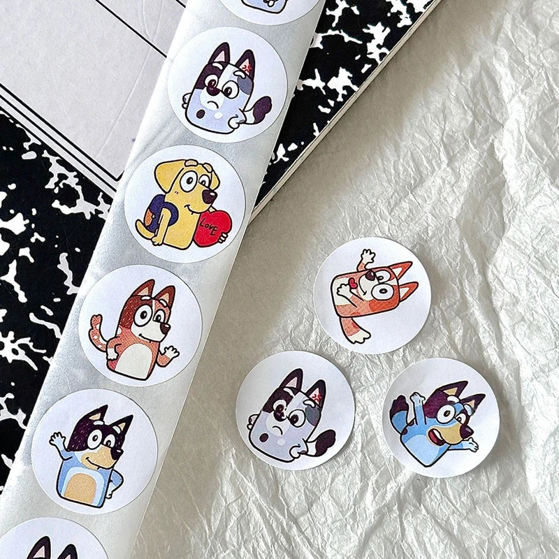 Bluey Bingo Dog Stickers roll and loose stickers on notebook, perfect for crafts and decorating children's projects.
