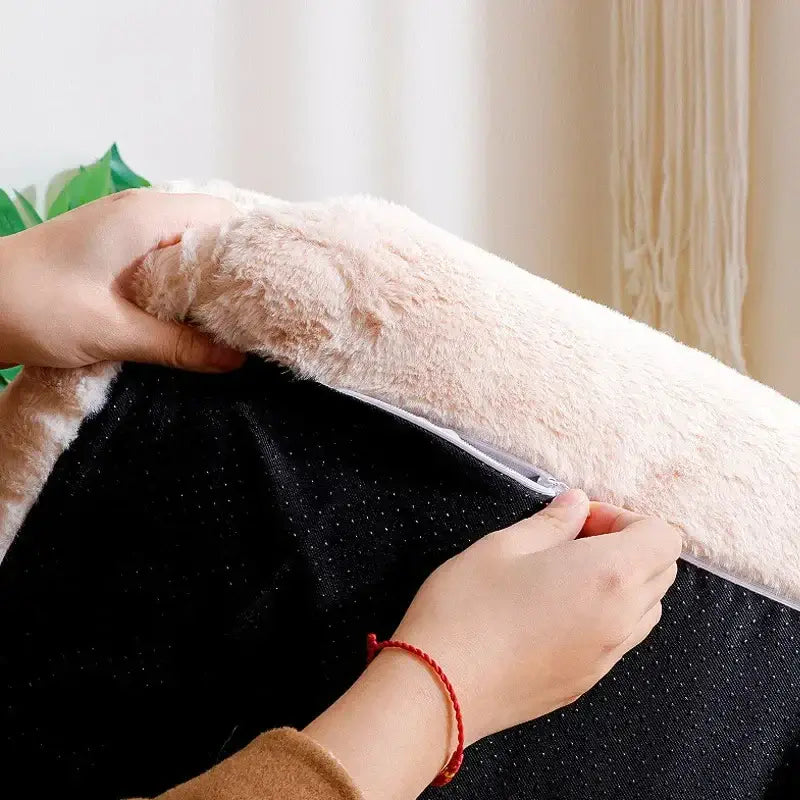 person holding the soft, plush cover of a luxurious cat bed sofa, showcasing its premium materials and comfort.